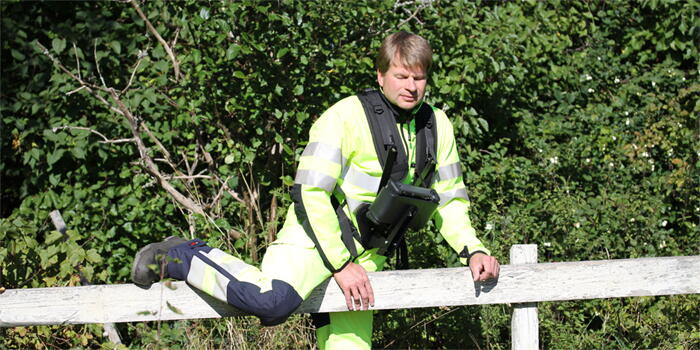 Ung man klättrar över staket